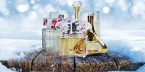 Montagem com frascos de perfume em destaque e um cenário de inverno ao fundo
