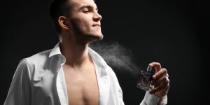 Homem de camisa aberta se perfumando