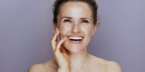 Close no rosto de uma mulher sorridente de cerca de 40 anos